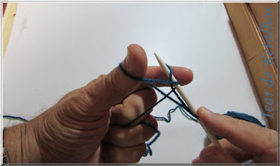 Foto mostrando a agulha pegando o laço do dedo indicador para a montagem à italiana de pontos do tricô