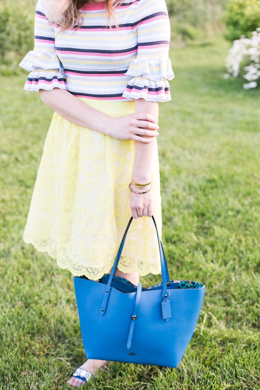 Bijuleni | Colourful ruffle sleeve sweater with lace eyelet yellow party skirt and Coach Tote