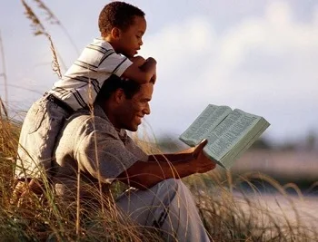 pai lendo a bíblia com filho