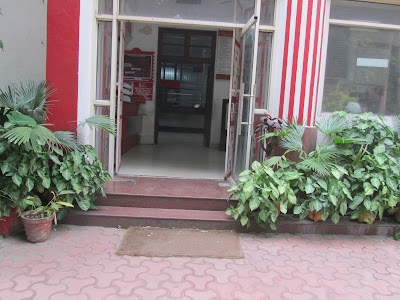 Photo showing stepped entry to post office, high counters and use of granite flooring which is slippery 