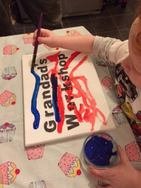 Toddler painting the canvas