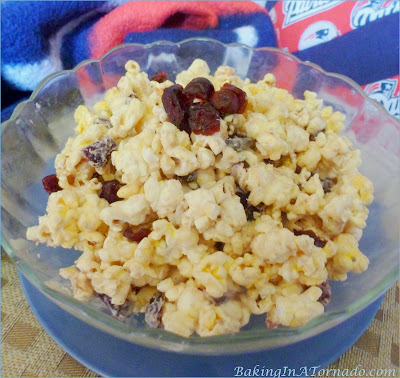 White Chocolate Cranraisin Popcorn: Fall flavors enhance this warm snack | Recipe developed by www.BakingInATornado.com | #recipe #popcorn #snack