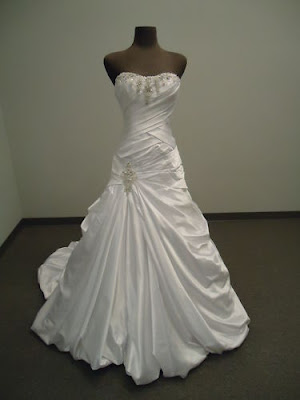 A-Line strapless wedding gown with criss-cross torso, ruffle style and embroidery.