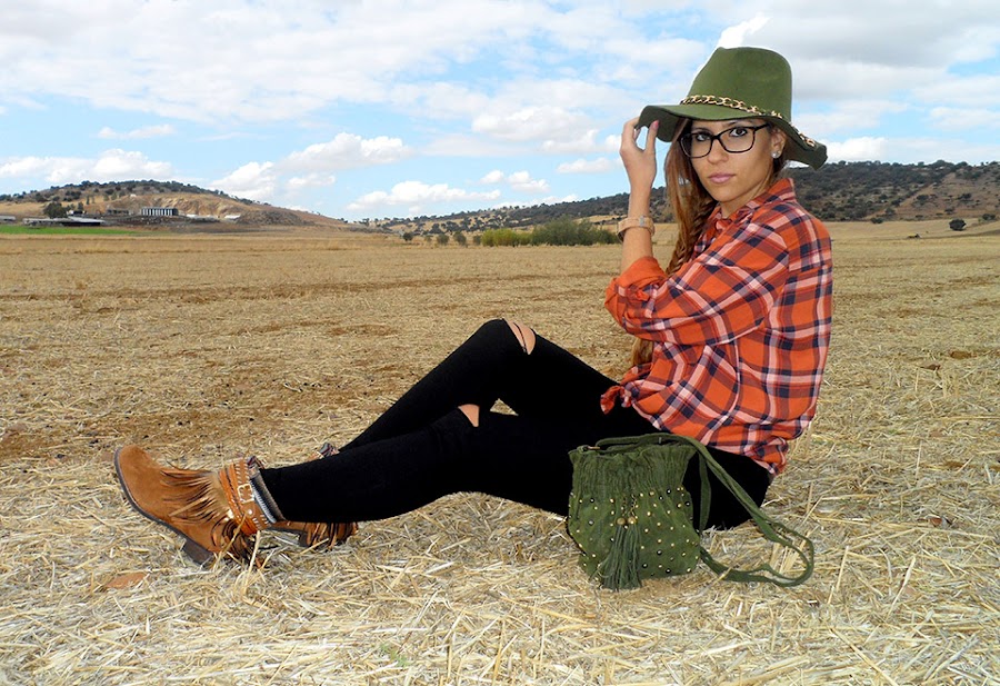 Camisa de cuadros con vaqueros rotos, botas boho, sombrero y bolso