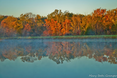 colorful fall trees reflected in water photo by mbgphoto