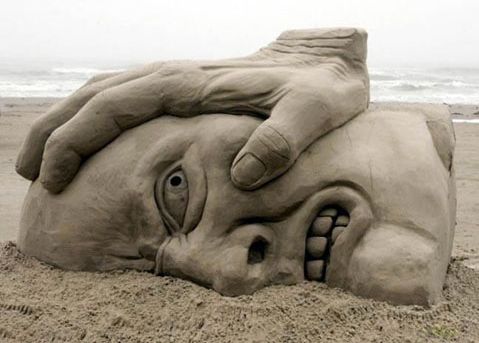 escultura de arena -cara y mano