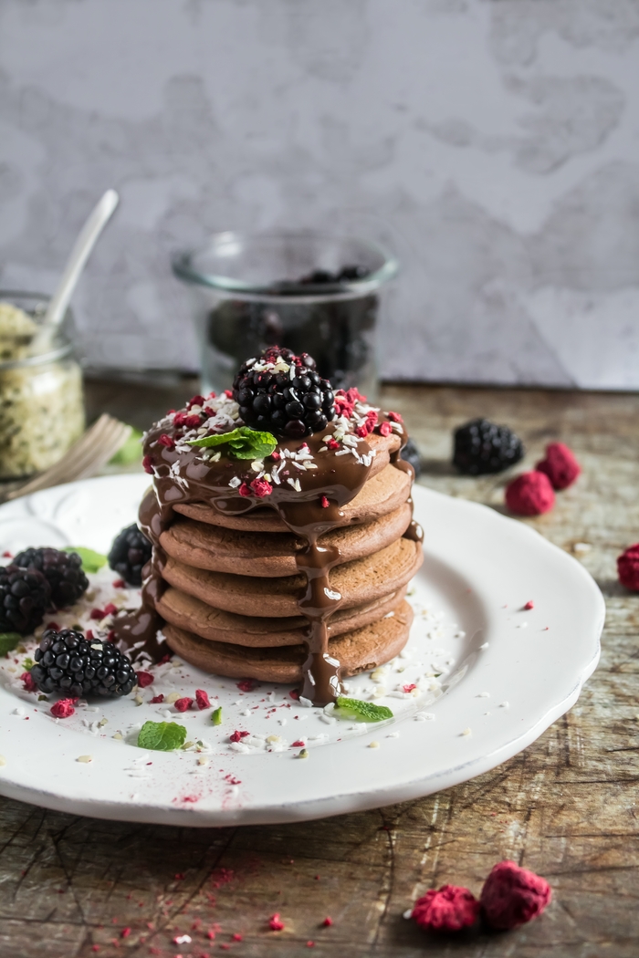 Healthier Blender Banana Pancakes topped with Chocolate Sauce and Blackberries