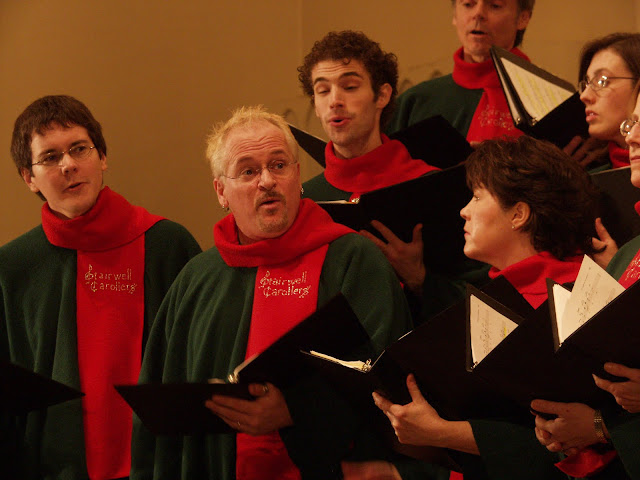 Pierre Massie directs the Stairwell Carollers from the tenor section