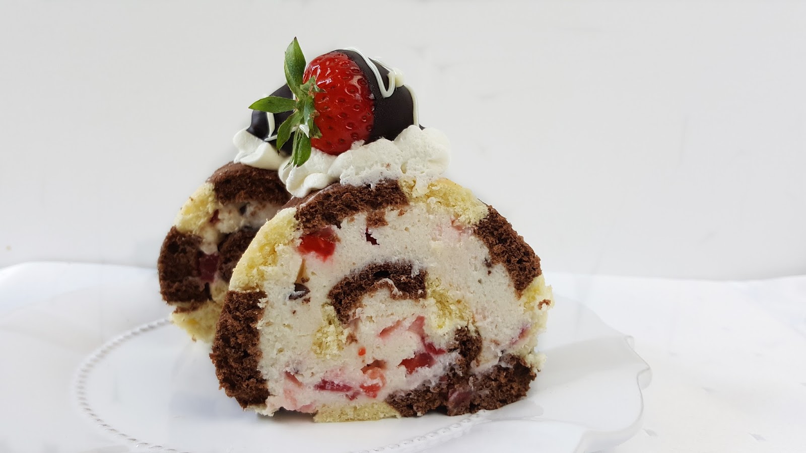 Zebra-Biskuitrolle mit Stracciatella-Erdbeerfüllung Zebra-Biskuitrolle mit Stracciatella-Erdbeerfüllung