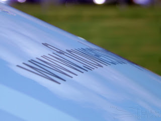 Close up of black vinyl lettering at an angle on an eggshell coloured van.