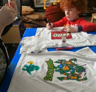 Children decorating t shirts with fabric paint pens