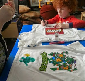 Children decorating t shirts with fabric paint pens
