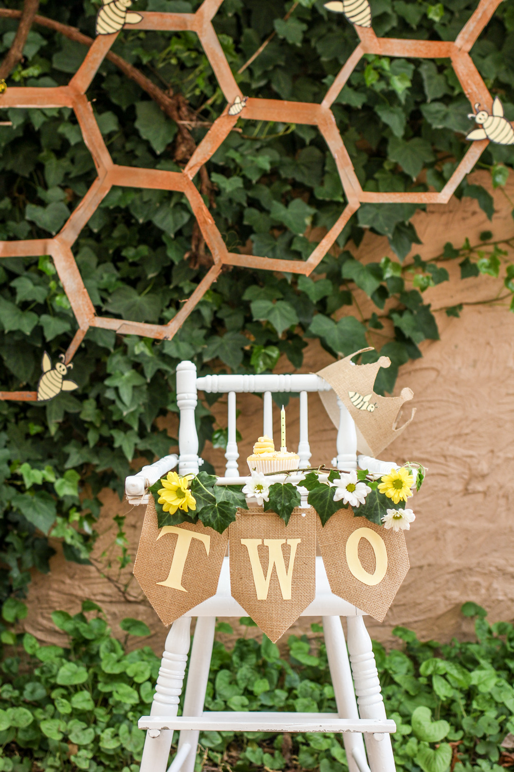 Vintage high chair bee hive smash cake with bunting daisy flowers and bumble bee honeycomb For more boys and unisex kids first birthday party inspiration visit the Goldfields Girl blog
