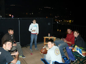 Friends gathered for a cook-out on a rooftop patio Friends gathered for a cook-out on a rooftop patio
