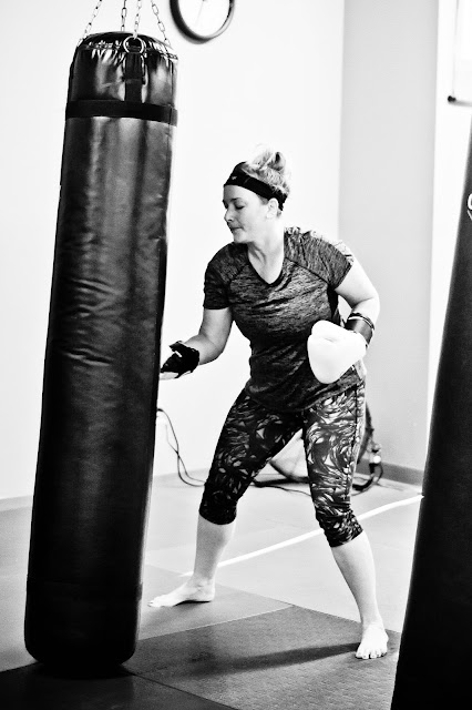 kickboxing students punch bags punch mitts press kettlebells and perform burpees at Fortress Fitness Kickboxing in Morristown TN
