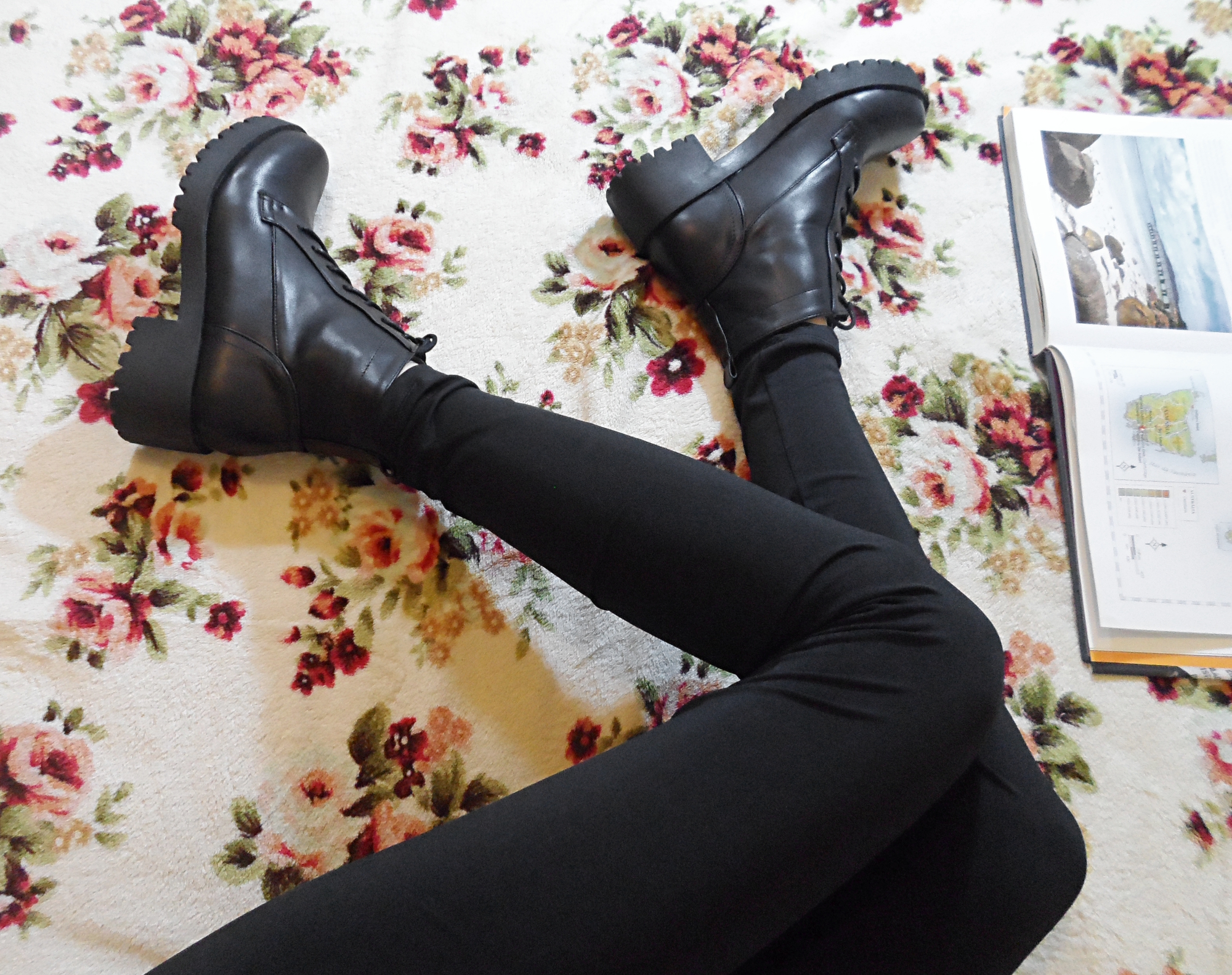 female legs wearing black combat boots and laying on the bed