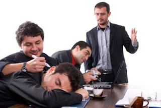Photo image of a business meeting where the executives seem much more interested in playing video games or playing pranks on sleeping coworkers.