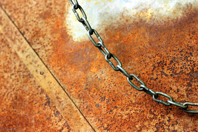 Minimalist Photo of Hanging Iron Chain On A Rusty Textured Background
