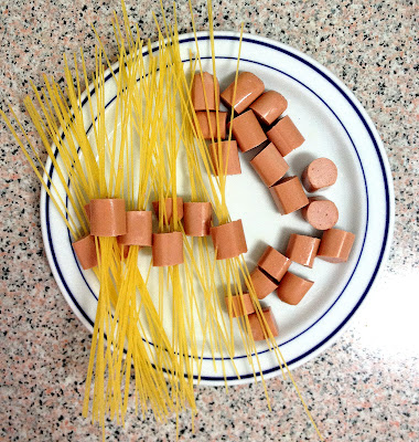 Espaguetis duros pinchados en salchichas