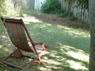 Deck chair on my lawn in dappled sunlight