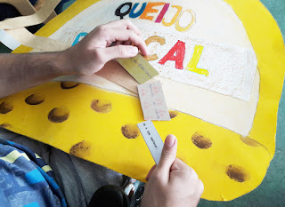 As mãos de um aluno a segurar as fichas da atividade dos provérbios