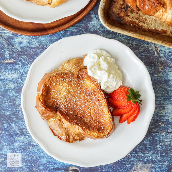 Creme Brulee French Toast served on a white plate with whipped cream and strawberries