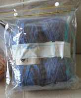 Clear snap-lock bag containing blue variegated sock yarn.