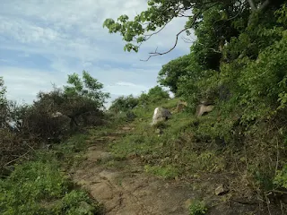 Climbing the steep rock face of Kabbaladurga during the ascent.