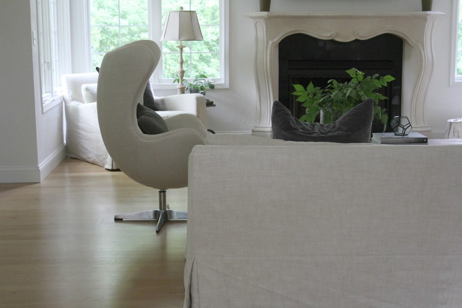 Belgian style living room with linen upholstery, white oak flooring, and stone fireplace - Hello Lovely Studio