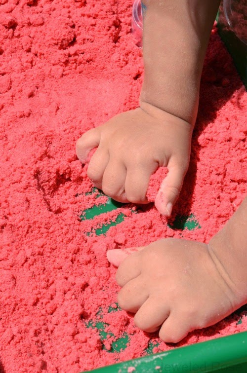 Watermelon Moon Sand Recipe- If you are unfamiliar with moon sand it is truly amazing stuff.  It is mold-able but crumbly and produces the best sandcastles.  It is really easy to make at home, too.