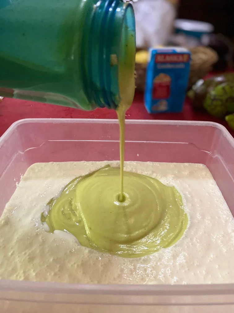 Folding in the avocado puree into the cream for the cheesy avocado ice cream