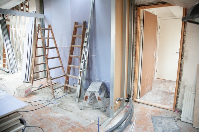 A chaotic room with ladders and equipment due to home renovation