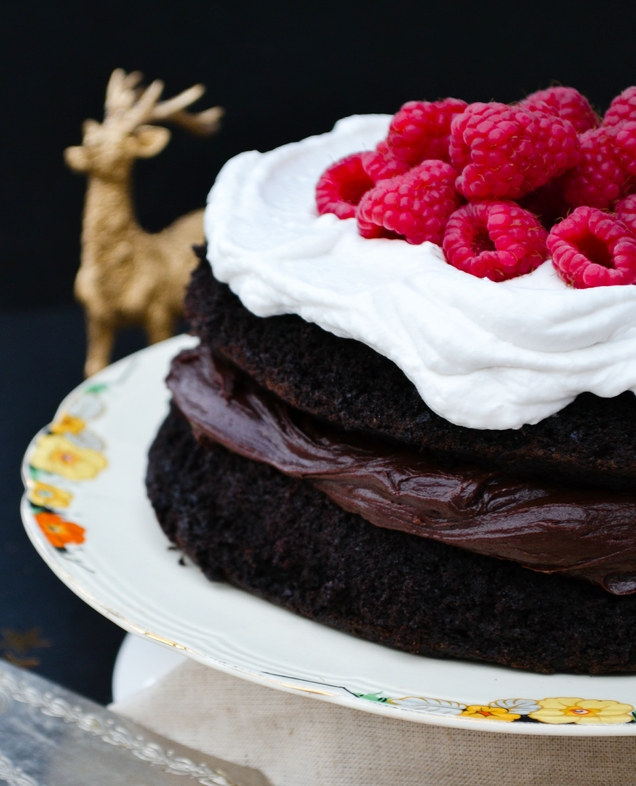An indulgent chocolate cake filled with chocolate buttercream and topped with whipped coconut cream and raspberries. Suitable for vegetarians and vegans.