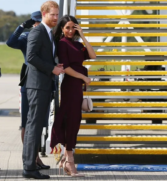 Meghan Markle wore Hugo Boss Eodora dark pink midi dress, and Aquazzura Casablanca style pumps she carried the Cuyana handbag