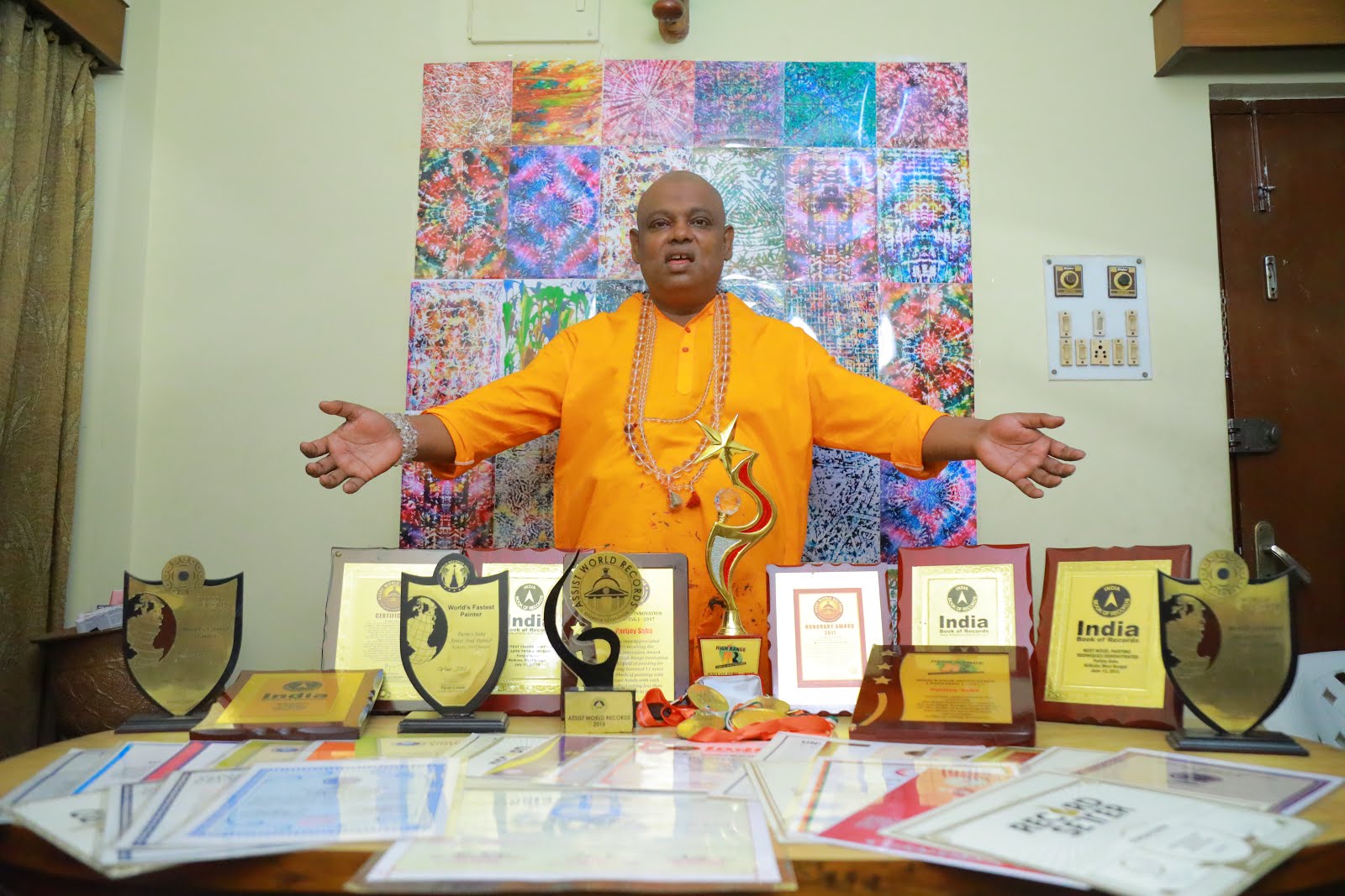 Parijoy Saha with certificates and awards.