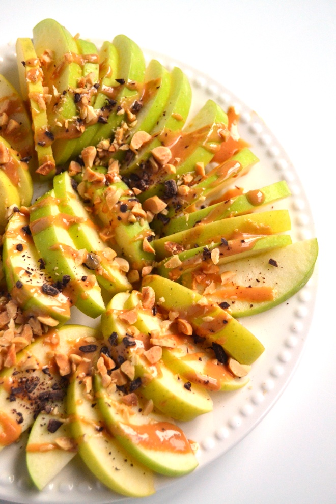 Apple Peanut Butter Nachos are ready in just 5 minutes and are kid-friendly! Topped with drizzly peanut butter, chocolate shavings and crushed peanuts for a delicious snack or dessert. www.nutritionistreviews.com