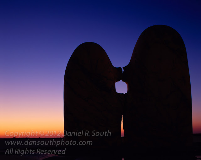 a fine art photograph of silhouetted statues at sunset in portugal