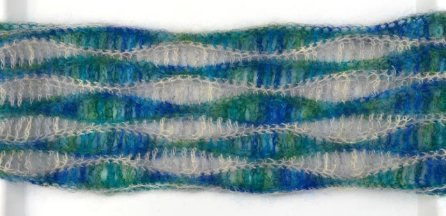 Horizontal view of the centre section of the scarf showing the wavy stripe pattern alternating blue-greens with silver-greys.