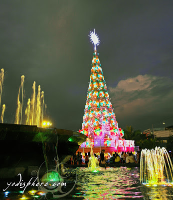 Giant Christmas Tree and colorful water fountain against the dark sky at SM Mall of Asia