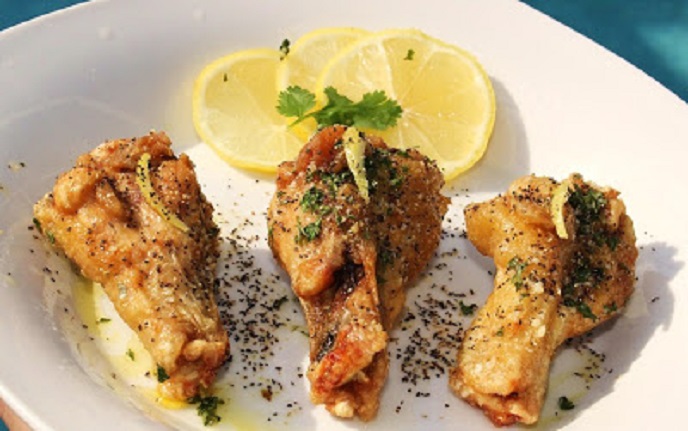 Lemon Garlic Chicken Wings fried or baked with a lemon and garlic herb coating sauce over the top