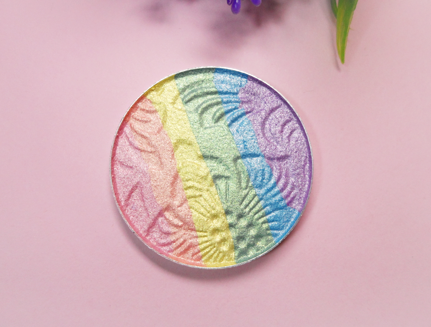 rainbow highlighter close-up on a rosy studio's background