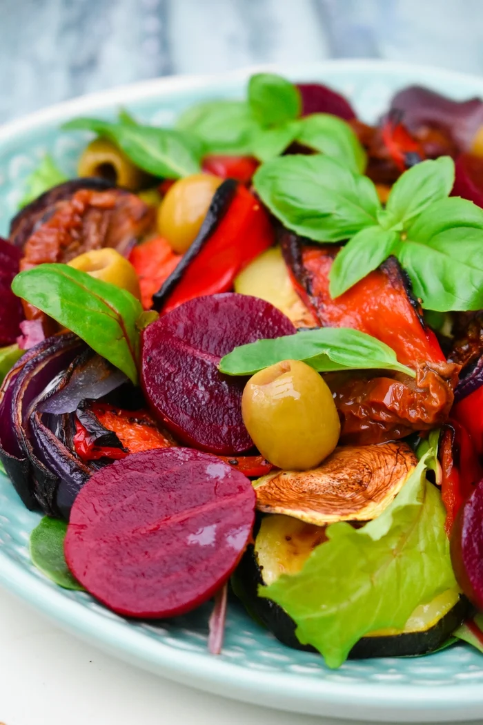 A substantial winter salad filled with roast vegetables on a bed of salad leaves, with sundried tomatoes, pickled beetroot, olives and a pesto balsamic dressing. Suitable for vegetarians and vegans.