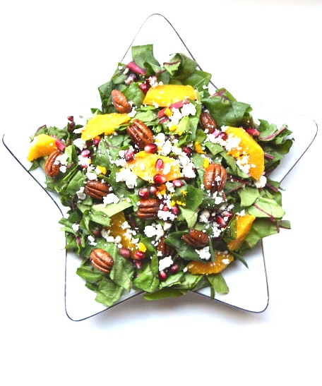 This Christmas Salad is packed full of nutrients and flavor with fresh oranges, pomegranate seeds, pecans, Swiss chard and blue cheese with a homemade dressing. www.nutritionistreviews.com