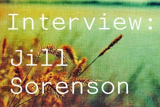 Image description: faded picture of a field with a close up on a wheat-like plant. The words Interview: Jill Sorenson on white on the foreground.