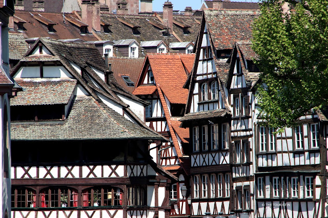 Facades of five different white and brown timbered houses.