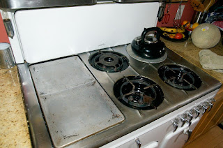 The griddle, broiler and burners of a vintage Chambers stove model B, also showing the folding cover.