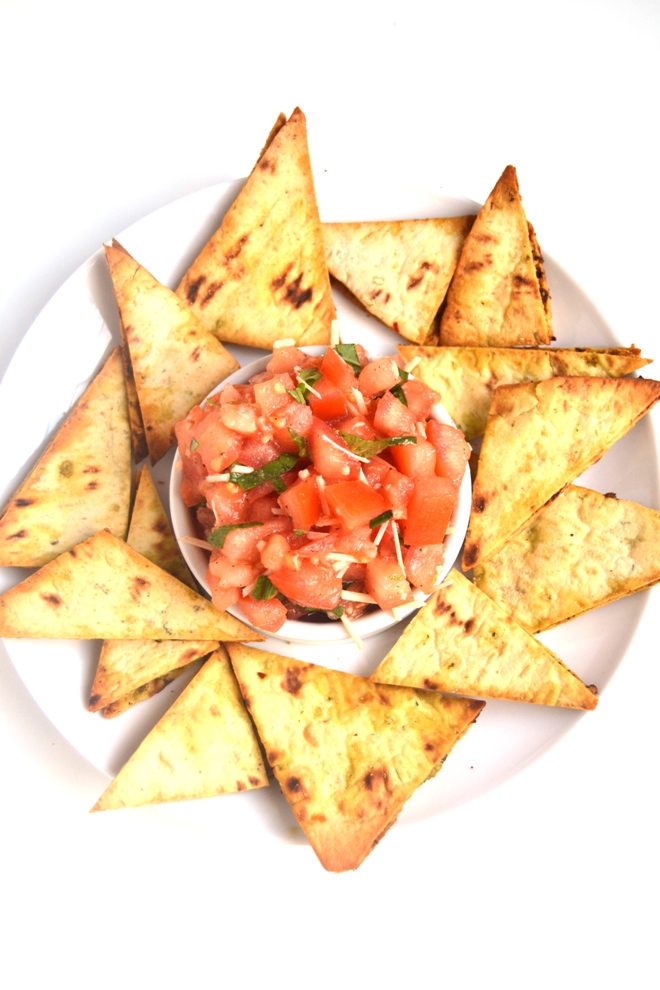 Bruschetta with Pesto Flatbread Chips make the perfect appetizer or snack with fresh tomatoes, garlic, Parmesan cheese and basil! The flatbread chips are thin, crispy and loaded with flavorful pesto. www.nutritionistreviews.com