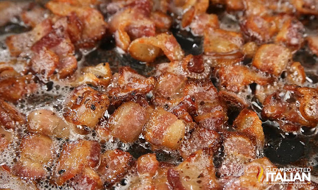 Jack Daniels Mac and Cheese pieces of crispy bacon cooking in a pan