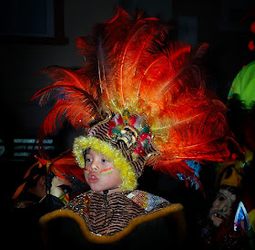 Kid wearing indigenous carnival feathered costume