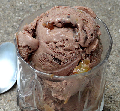 A close up photo of chocolate rum raisin ice cream in a clear dish.